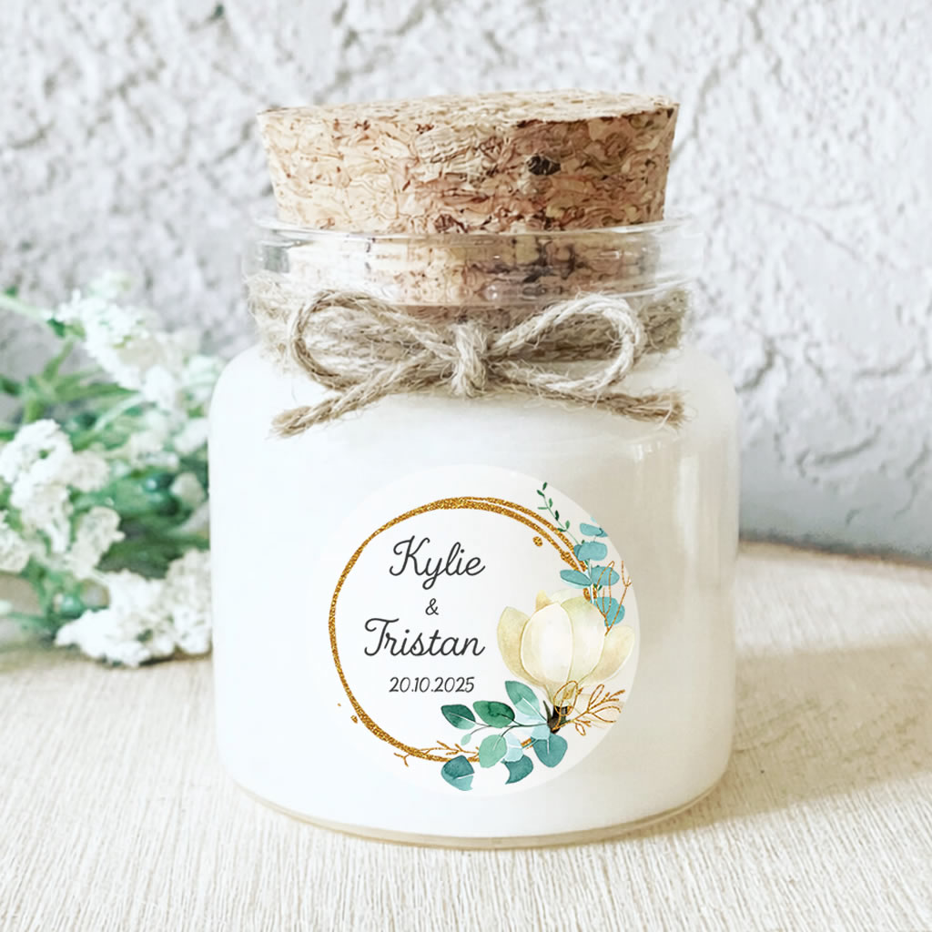 Bougie personnalisée mariage avec fleur blanche et feuillage d’eucalyptus, une création chic et raffinée pour vos invités.